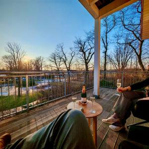 two people sitting on a porch with glasses of wine at Deluxe Apartment im Grünen mit Balkon und Frühstück im Hotel Reindahls in Wilkendorf
