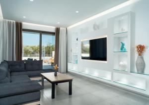 a living room with a couch and a tv at Christian Luxury Villa in Tsilivi