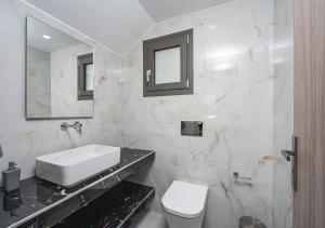 a bathroom with a sink and a toilet and a mirror at Christian Luxury Villa in Tsilivi +74 photos