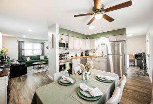 a kitchen and living room with a table and a ceiling fan at Meadow View BNB in Lima