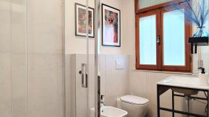 a bathroom with a shower and a toilet and a sink at I Marosi Beach Apartment in Lido di Fermo +32 photos