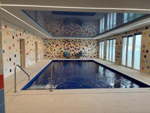 a swimming pool in a large room with tiles at DOMITYS - Le Tandem in Lens