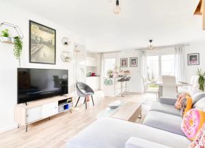 a living room with a couch and a flat screen tv at Casa Via - Entre Caen & la mer in Cambes-en-Plaine