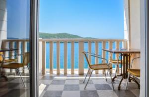 Un balcón con mesas y sillas y vistas al océano. en Hotel Porat, en Neum