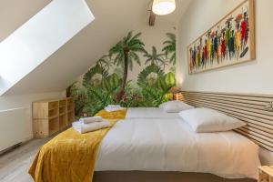 a bedroom with a large white bed with a yellow blanket at La Maison de Papy Ours,Family ,Air-conditioned in Bourré
