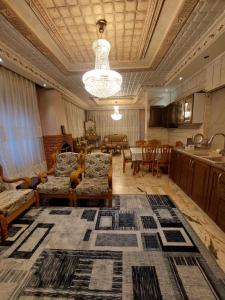 a living room with couches and a table and a kitchen at شقة مفروشة في البنيات - بالقرب من جامعة البتراء in Amman +7 photos