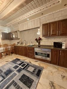 a kitchen with wooden cabinets and a counter top at شقة مفروشة في البنيات - بالقرب من جامعة البتراء in Amman