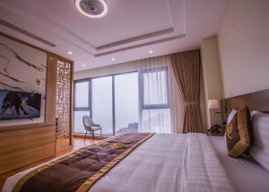 Un dormitorio con una cama grande y una ventana grande. en Khách sạn Vũ Phong Prime, en Sầm Sơn 15 fotos más