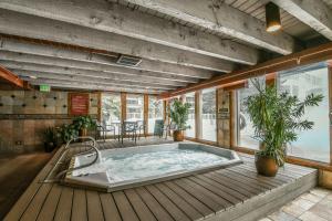 a hot tub on a wooden deck with plants at Lakeside 1496 by SummitCove Lodging in Keystone