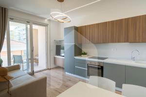 アルバ・アドリアティカにあるHomiday - Residenza Incantoのソファとテーブルのあるキッチンとリビングルーム