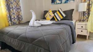 Sunsetcrest Tranquil Getaway في Anse La Raye: غرفة نوم عليها سرير وبجعة