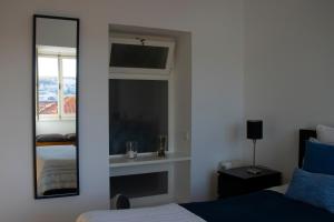 a bedroom with a mirror and a bed and a window at Joia da Mouraria in Lisbon
