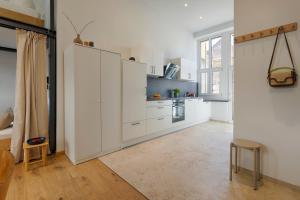 a white kitchen with white cabinets and a window at homie stay am spital in Würzburg