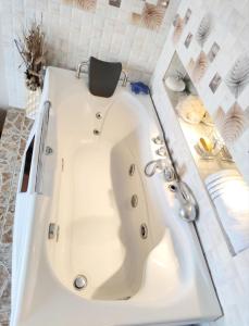 a white bath tub in a white bathroom at Maison d'hôtes Lac Mandroseza in Antananarivo +7 photos