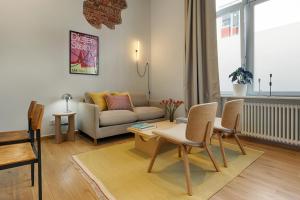 a living room with a couch and a table and chairs at homie stay am spital in Würzburg