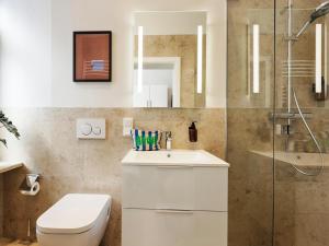 a bathroom with a toilet and a sink and a shower at homie stay am spital in Würzburg