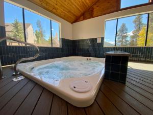 a large bath tub in a room with windows at Quicksilver 1613 by SummitCove Lodging in Keystone