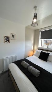 Postel nebo postele na pokoji v ubytování THE SCHOOL HOUSE, DUNDEE- 3 bed bungalow TV's in all rooms, 2 double rooms and one queen size where the bed can be split into 2 twin beds, 2 bathrooms, fully equipped kitchen, FREE off street parking, WiFi, long stay rates available with HONEYCOMB HOSTS