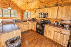 ピジョン・フォージにあるBlue Bear Lodge near Dollywood! 1 mile off PKWY Community Pool Hot tub Game Rmの木製のキャビネットとコンロ付きオーブンを備えたキッチン