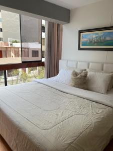 a bedroom with a large white bed with a window at View of the Pacific Ocean in Lima