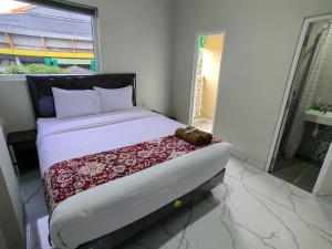 a bed in a room with a large window at Joy Hotel in Hajimana