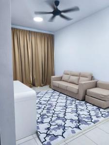 een woonkamer met een bank en een plafondventilator bij Ustazahhomestay in Bemban