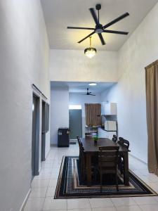 een eetkamer met een tafel en een plafondventilator bij Ustazahhomestay in Bemban +15 foto's