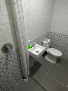 a bathroom with a toilet and a sink at Joy Hotel in Hajimana