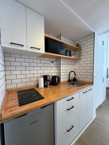 Una cocina con gabinetes blancos y una encimera de madera. en Ideal Apartment in Bariloche, en San Carlos de Bariloche