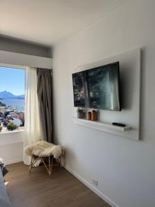 Una sala de estar con un televisor de pantalla plana en una pared. en Ideal Apartment in Bariloche, en San Carlos de Bariloche