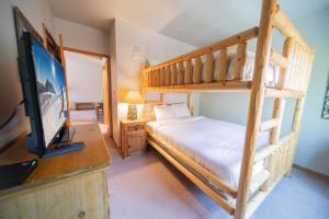 ein Schlafzimmer mit einem Etagenbett und einem Flachbild-TV in der Unterkunft Black Bear 8064 by SummitCove Lodging in Keystone
