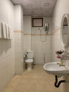 a bathroom with a toilet and a sink at Hung Vuong Hotel in Ben Tre