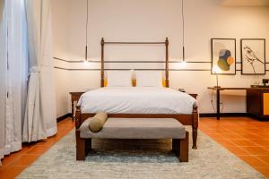 a bedroom with a bed with a chair and a table at voco Lake Nicaragua - Granada by IHG in Granada