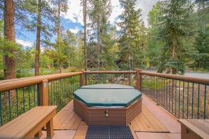 a hot tub on a deck with a bench at Starfire 1992 by SummitCove Lodging in Keystone