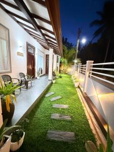 eine Terrasse mit Gras und Bänken an einem Haus in der Unterkunft Airport Heaven's Corner Home Stay Negombo in Etgala