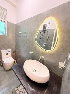 ein Badezimmer mit Waschbecken, Toilette und Spiegel in der Unterkunft Airport Heaven's Corner Home Stay Negombo in Etgala