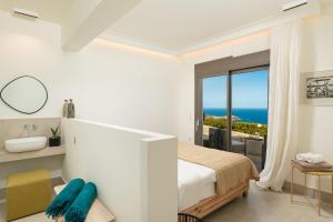 sypialnia z łóżkiem i widokiem na ocean w obiekcie Minimalist Mediterranean Blue key Villa with Sea View & Infinity Heated Pool w mieście Agia Pelagia +37 zdjęć