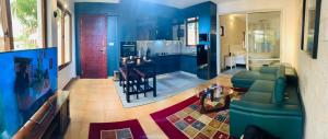 a large living room with blue walls and a kitchen at Englishpoint Marina Villa in Mombasa