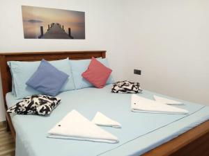 a bed with colorful pillows on top of it at Tiamo Rooms in Matara