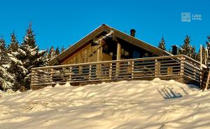 a log cabin in the snow with trees in the background at Modern sports cabin on Sjusjøen with sauna and waxing room in Ringsaker