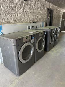 three washing machines are lined up against a wall at Heritage Place Hotel in Iuka