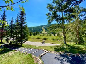 a person walking down a path in a park at Tenderfoot Lodge 2643 by SummitCove Lodging in Keystone