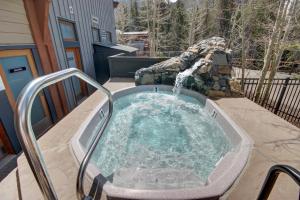 a hot tub with a waterfall in a backyard at Black Bear 8035 by SummitCove Lodging in Keystone