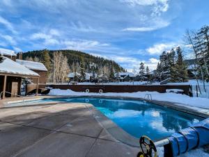 a swimming pool covered in snow next to a house at Wild Irishman 1043 by SummitCove Lodging in Keystone