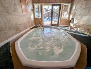 a large bath tub in the middle of a room at Wild Irishman 1043 by SummitCove Lodging in Keystone