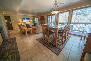 a dining room and living room with a table and chairs at Wild Irishman 1043 by SummitCove Lodging in Keystone