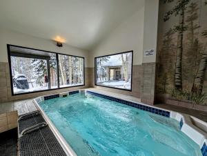 a large swimming pool in a room with two windows at Pines 2129 by SummitCove Lodging in Keystone