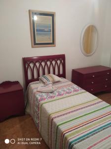 a bedroom with a bed and a dresser and a mirror at Bienvenida in Almería