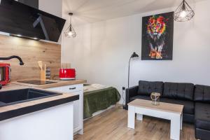 una cucina e un soggiorno con divano di Apartamento Suite Puerta del Sol II a Montijo