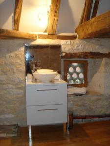 baño con lavabo blanco en un edificio de piedra en Le pigeonnier, en Virac